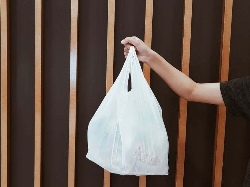 holding a white plastic bag